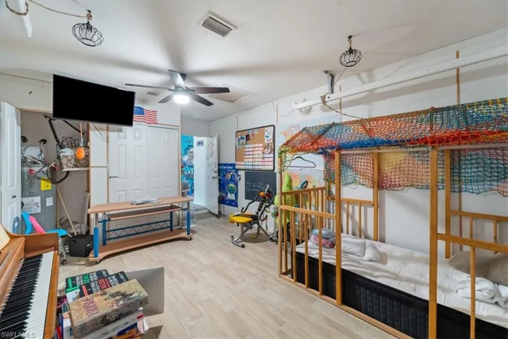 Bedroom with a closet, wood finished floors, ceiling fan, and electric water heater