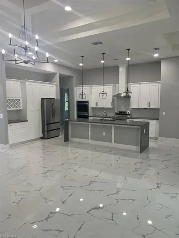 Kitchen featuring pendant lighting, fridge, a large island, and extractor fan