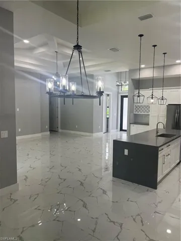 Kitchen with sink, white cabinetry, and light tile patterned flooring