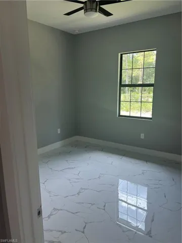 Unfurnished room with tile patterned flooring and ceiling fan