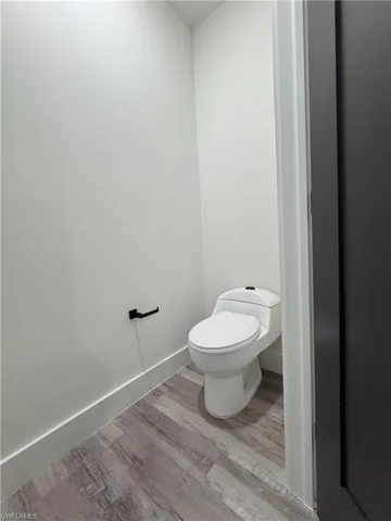 Bathroom with toilet and hardwood / wood-style floors