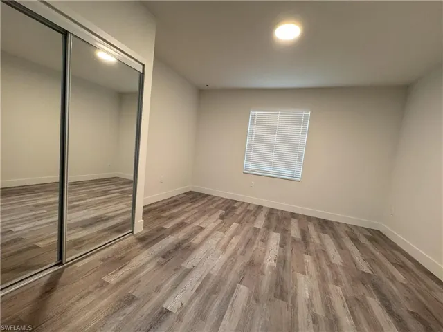 Unfurnished bedroom with wood-type flooring and a closet
