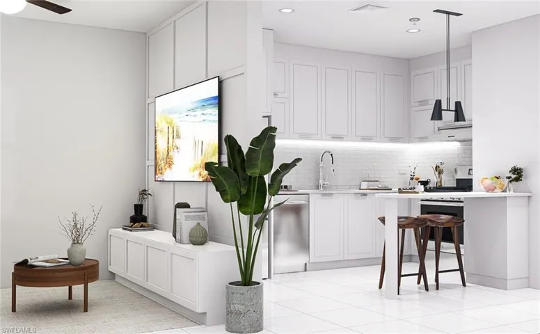 Kitchen featuring white cabinetry, decorative backsplash, a breakfast bar area, light tile patterned floors, and appliances with stainless steel finishes