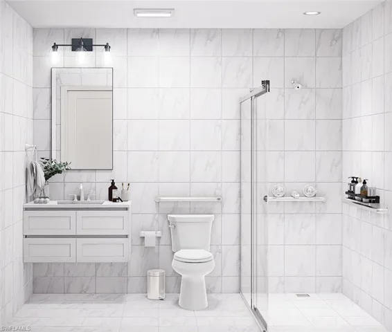 Full bathroom featuring a stall shower, vanity, and tile walls