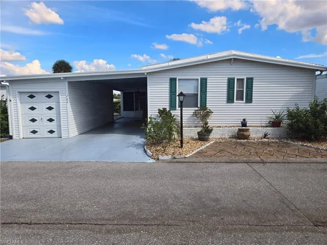 View of front of property with driveway and an attached carport