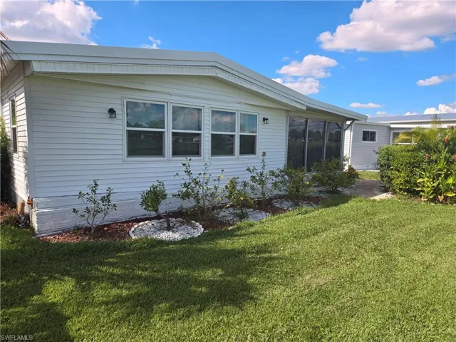 Rear view of house featuring a yard
