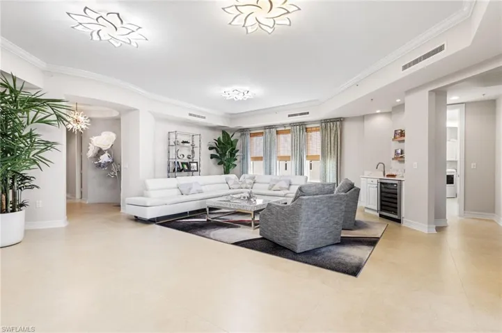 Views of the river from your main living area which has a wet bar and wine cooler.  Quartz countertops and sink. The custom lighting is a unique feature of this condo. Tray ceilings and crown molding, 8ft doors throughout. 24 x 24 tile flooring.