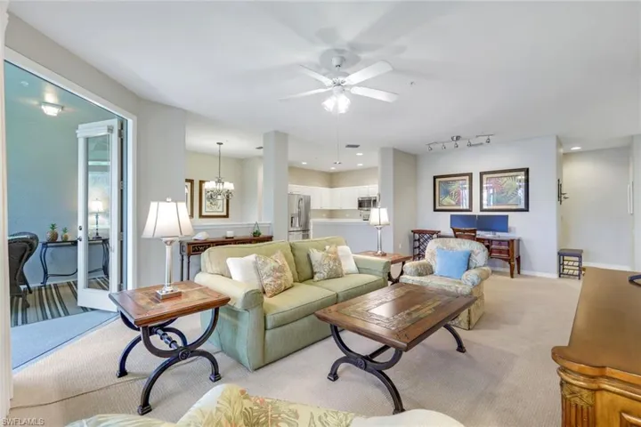 Living room featuring light colored carpet, ceiling fan, recessed lighting, rail lighting, and a chandelier