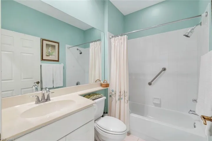 Full bathroom with shower / bath combination with curtain, vanity, and tile patterned floors