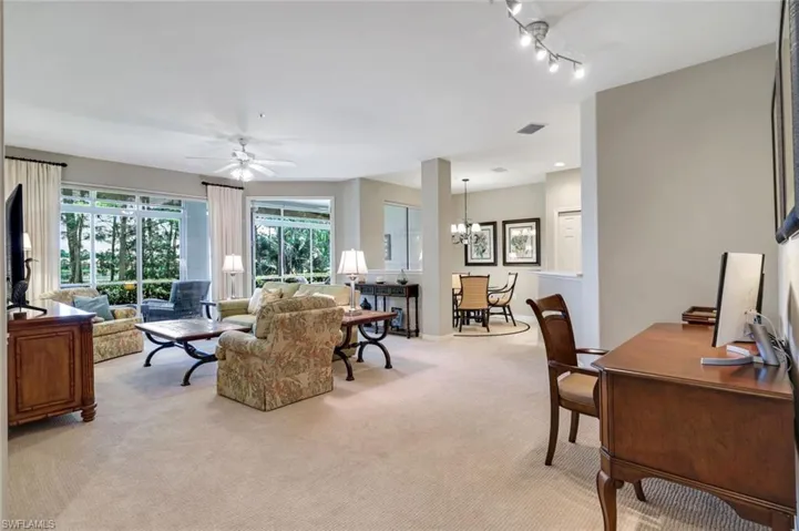 Living area with light colored carpet, a chandelier, a ceiling fan, a desk, and recessed lighting