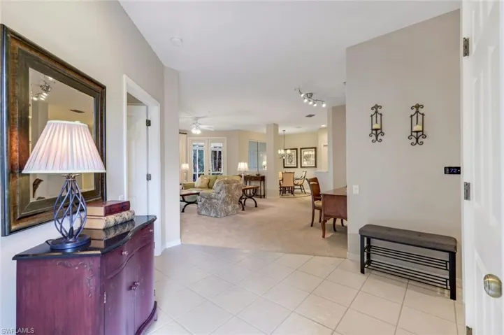 Hall with light carpet and light tile patterned floors