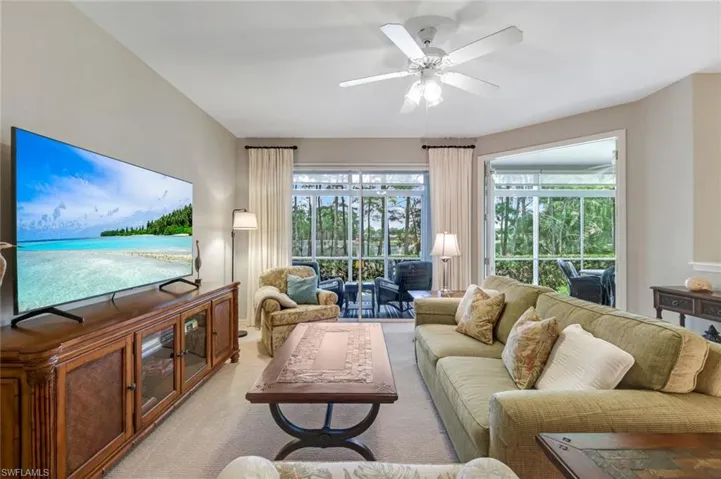 Living room with a ceiling fan and light colored carpet