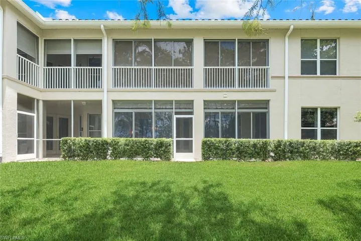Rear view of property featuring stucco siding and a lawn