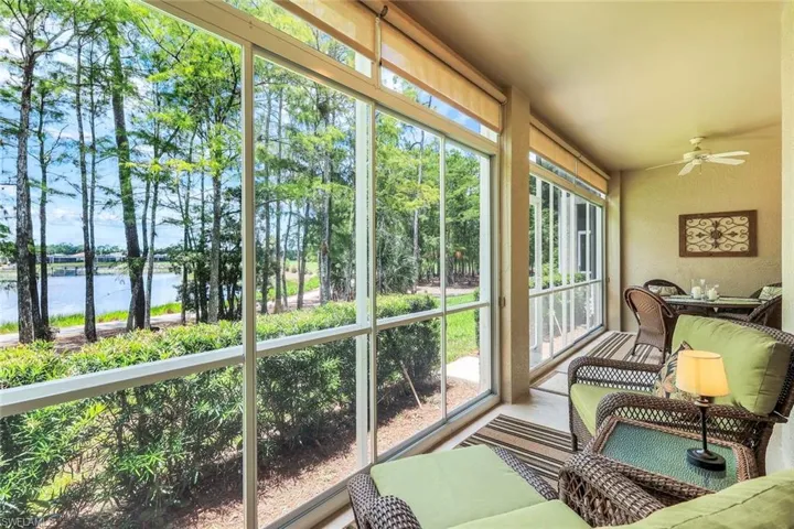 Sunroom / solarium featuring a water view, ceiling fan, and a textured wall, plexiglass enclosure