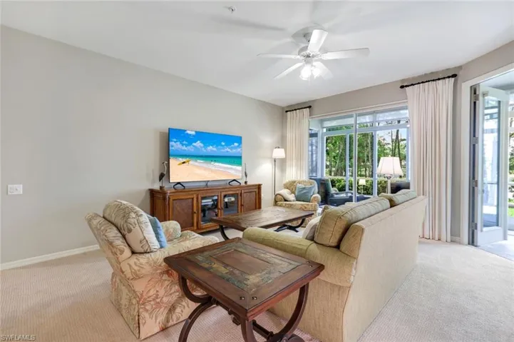 Living area with light carpet and a ceiling fan