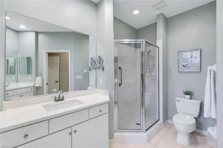 Full bath with vanity, a shower stall, tile patterned floors, and recessed lighting