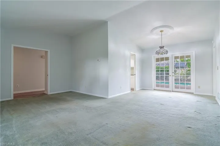 Living And Dining Rooms With Soaring Vaulted Ceilings And French Doors To The Lanai.