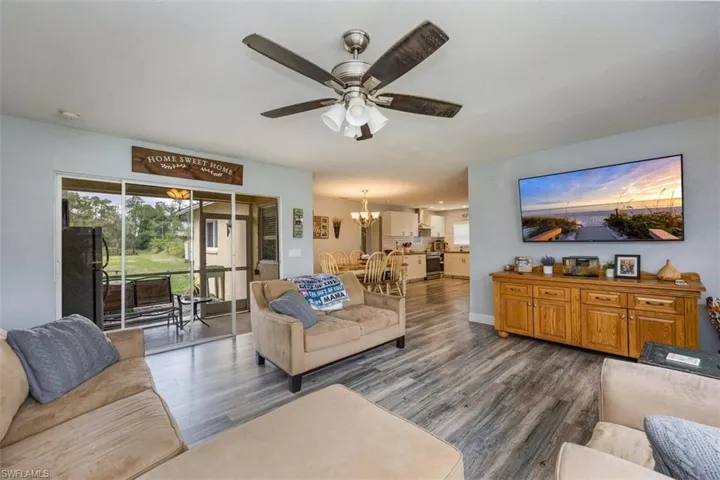 Living area featuring a chandelier, wood finished floors, and ceiling fan