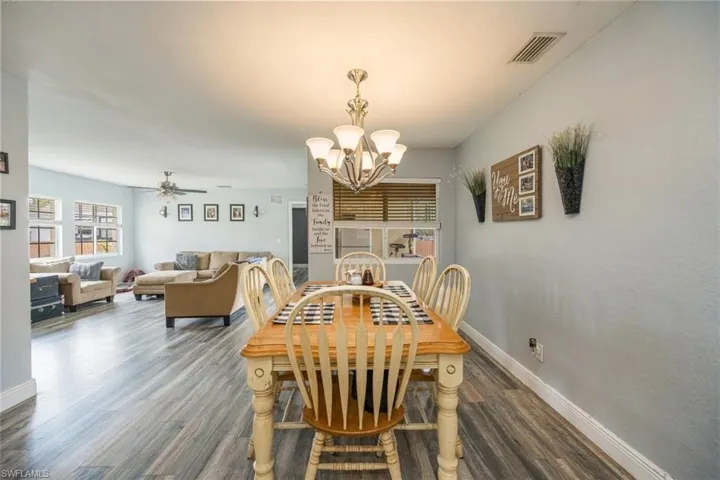 Dining area featuring a chandelier, dark wood-style floors, and ceiling fan