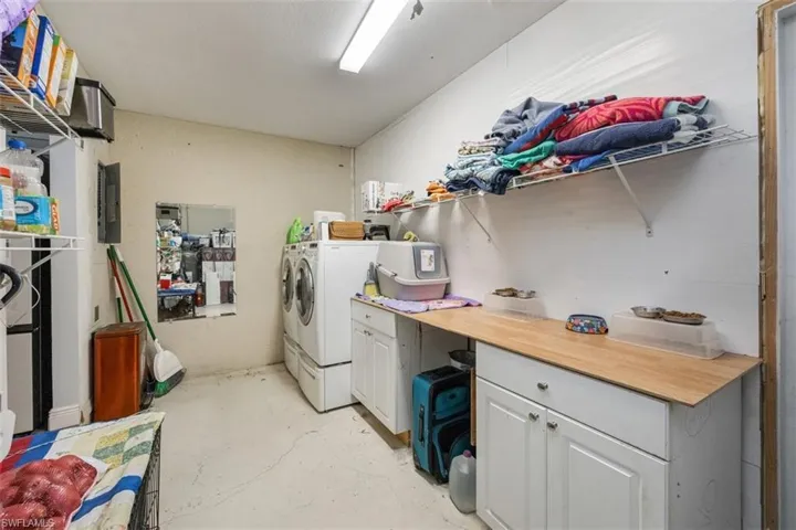Laundry area with concrete flooring, independent washer and dryer, and electric panel