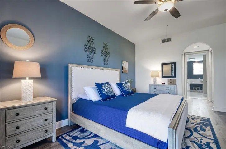 Bedroom with ceiling fan and dark wood-type flooring