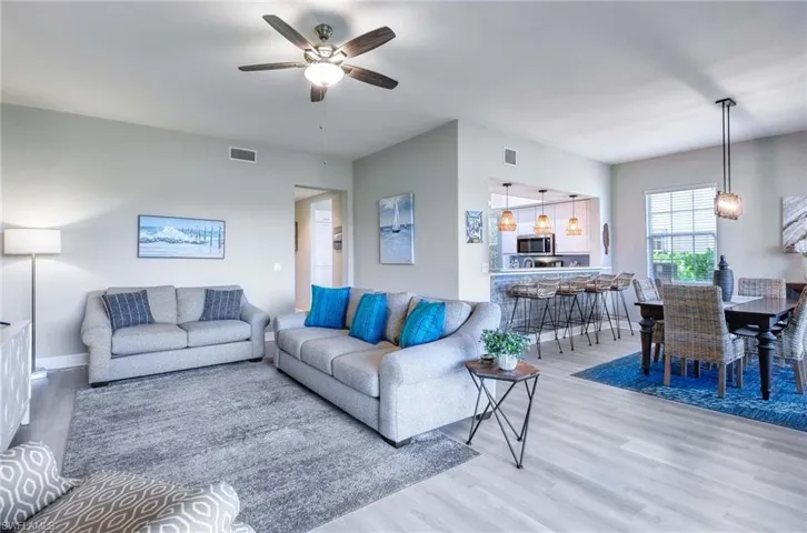 Living room with ceiling fan and light hardwood / wood-style flooring
