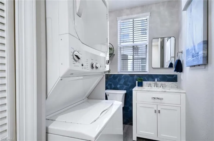 Laundry area with NEW half bath added, full size stacked washer / dryer