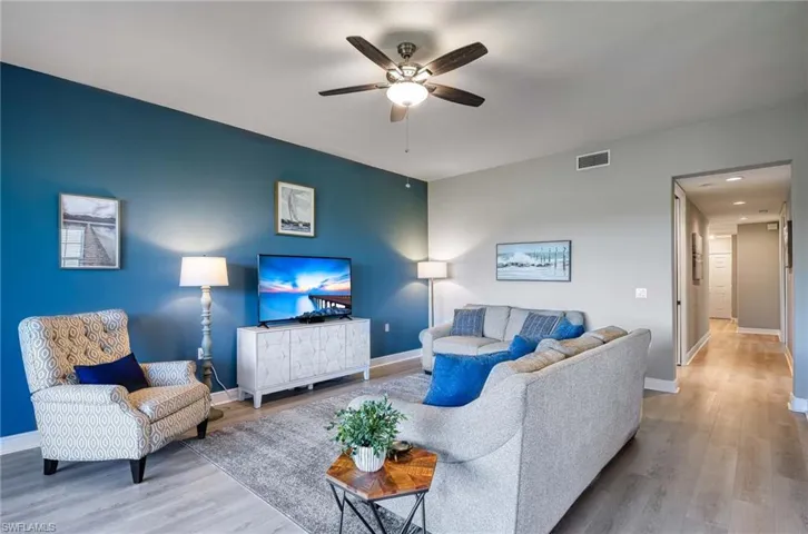 Living room featuring ceiling fan and light hardwood / wood-style flooring
