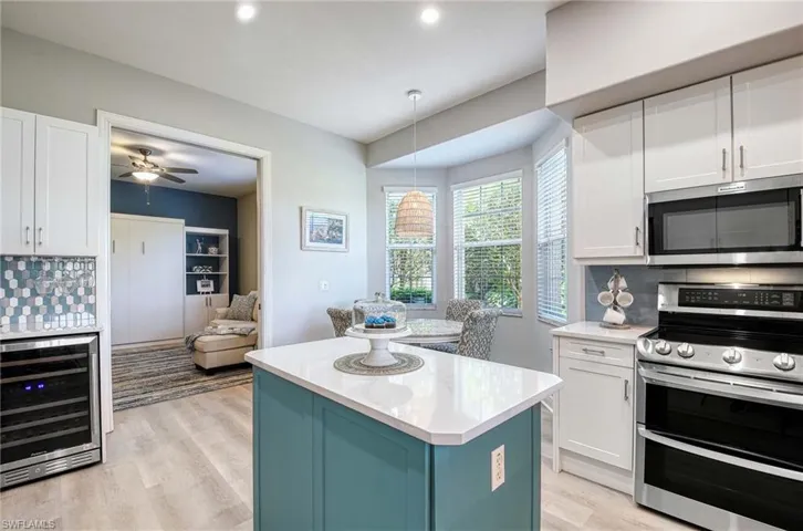 Kitchen with wine cooler, white cabinets, and stainless steel appliances