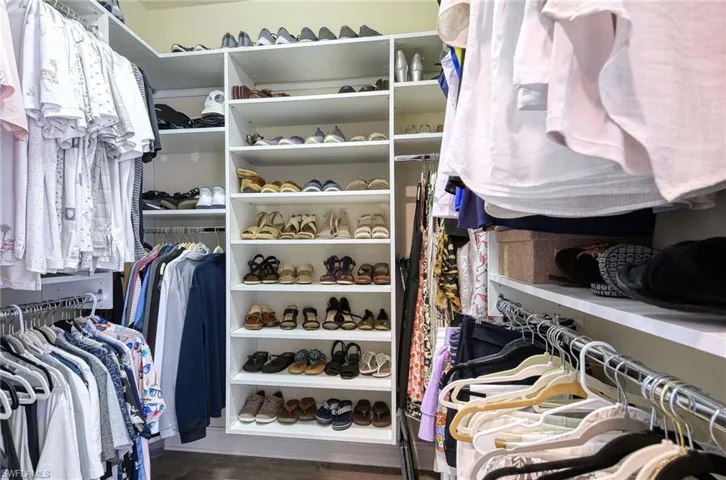 Spacious closet with dark hardwood / wood-style floors