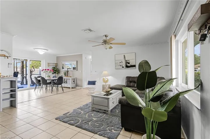 Living room with light tile patterned floors and ceiling fan