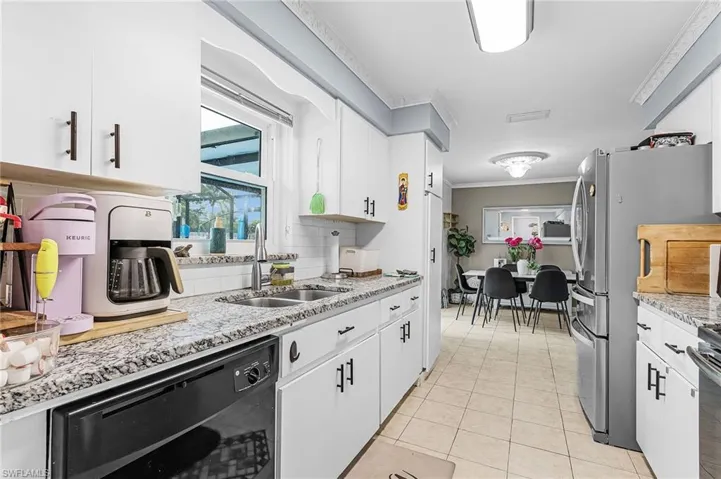 Kitchen with dishwasher, white cabinetry, ornamental molding, backsplash, and light tile patterned floors