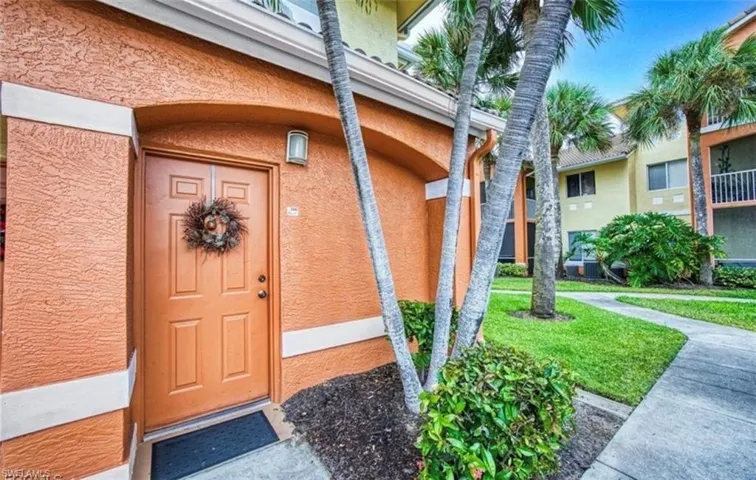 Entrance to property featuring stucco siding and a lawn