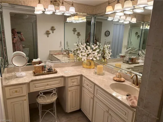 Bathroom featuring a shower with door, vanity, toilet, and tile patterned floors