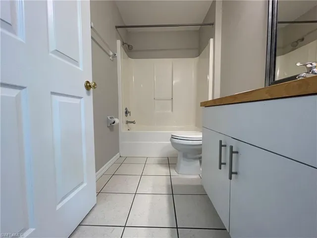 Full bathroom featuring vanity, light tile patterned floors, and tub / shower combination