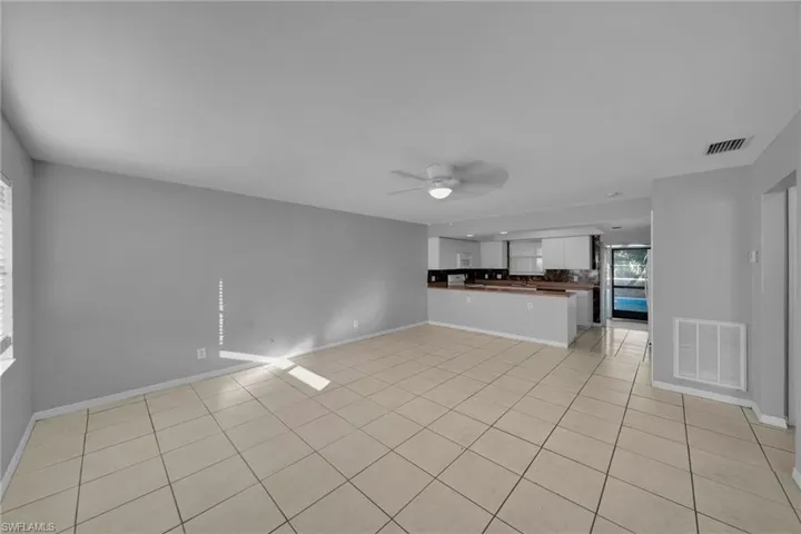 Unfurnished living room with a ceiling fan and light tile patterned floors