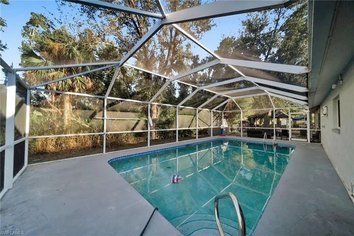 Swimming pool with a sunroom, a lanai, and a patio area