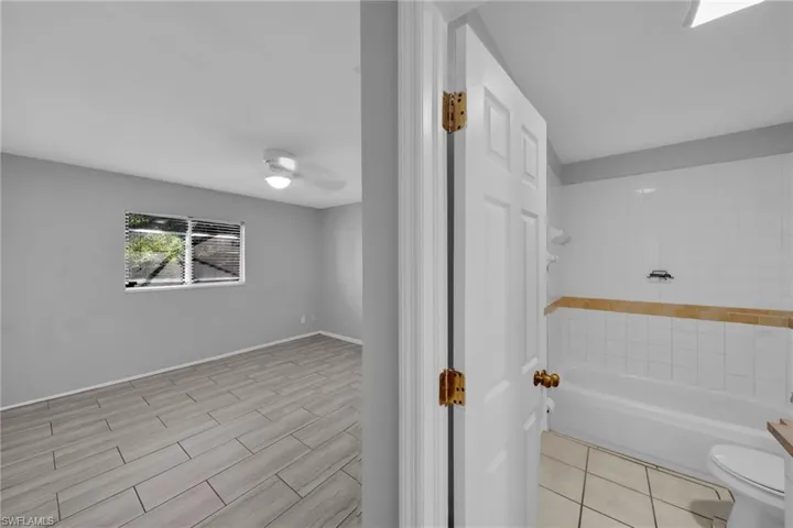 Bathroom featuring wood tiled floors and tub / shower combination