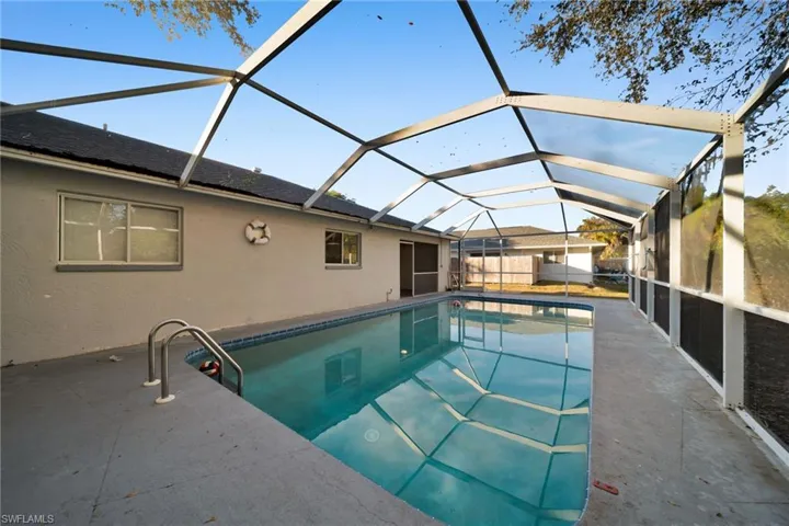Swimming pool featuring a lanai, a sunroom, and a patio