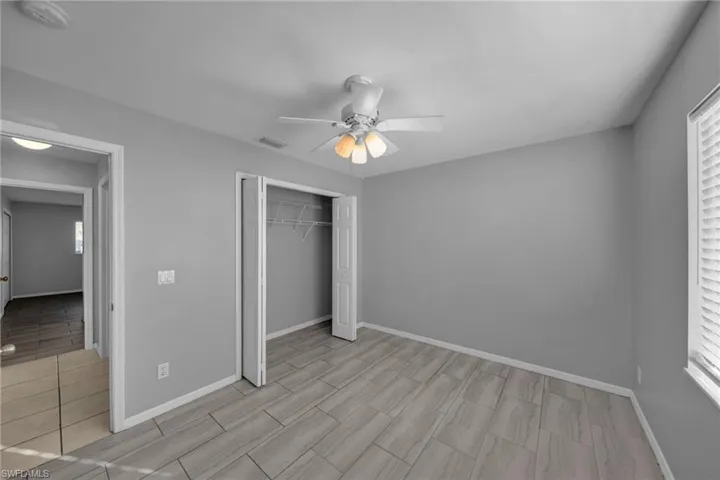 Unfurnished bedroom with a closet, ceiling fan, and wood finish floors