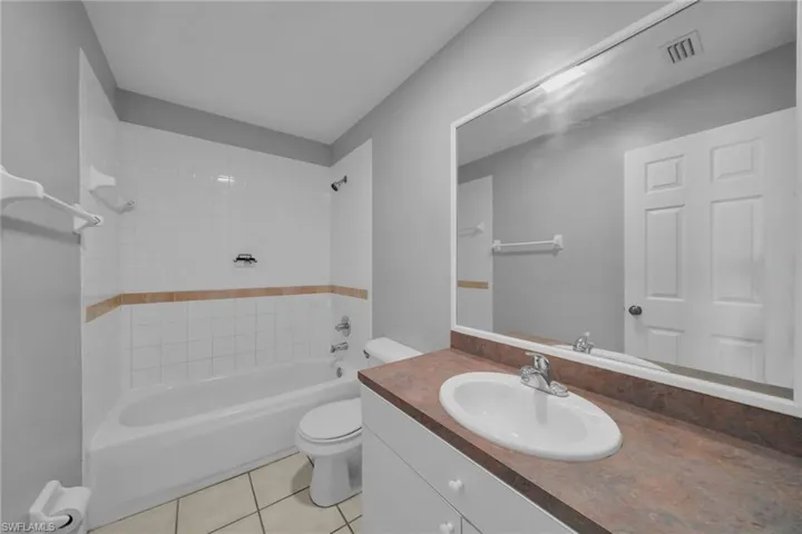 Bathroom featuring shower / bath combination, vanity, and light tile patterned floors