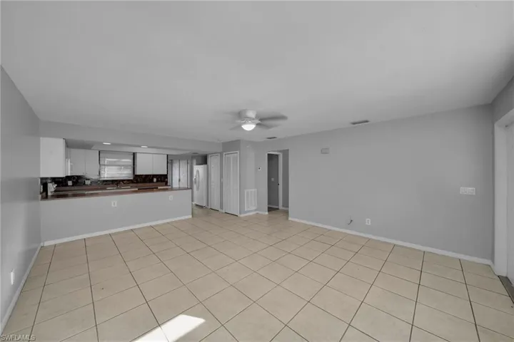 Unfurnished living room with a ceiling fan and light tile patterned floors
