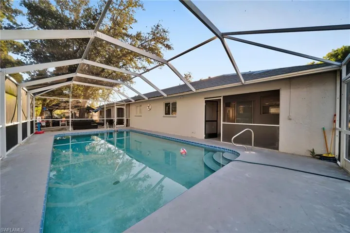 Swimming pool featuring a sunroom, glass enclosure, and a patio