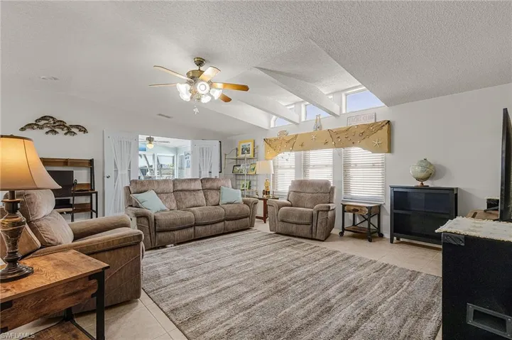 Living Room with a vaulted ceiling and ceiling-height windows for additional sunlight.