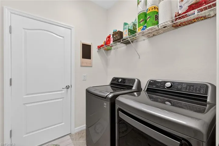 Laundry area with washing machine and clothes dryer and baseboards