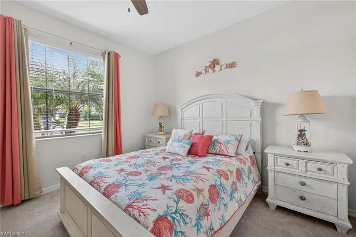 Bedroom with light colored carpet and ceiling fan