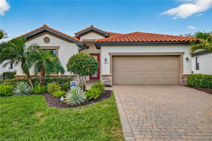 Mediterranean / spanish house with an attached garage, decorative driveway, a tiled roof, and stucco siding