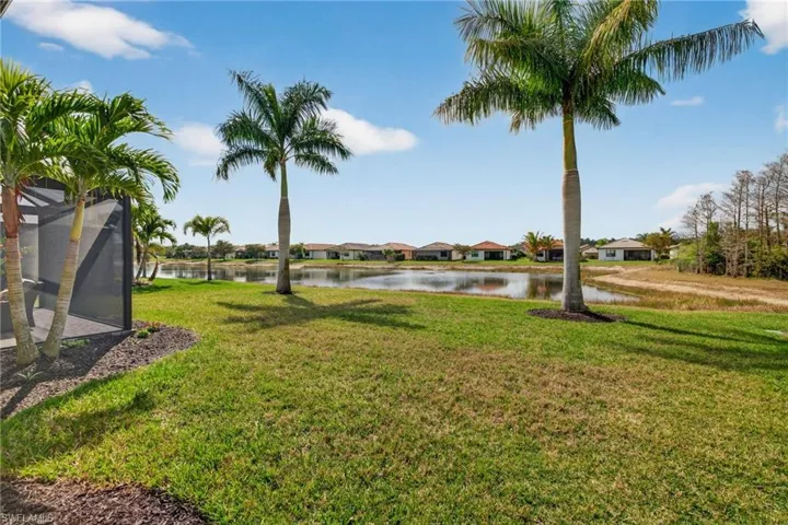View of green lawn with a water view, a residential view, and a lanai