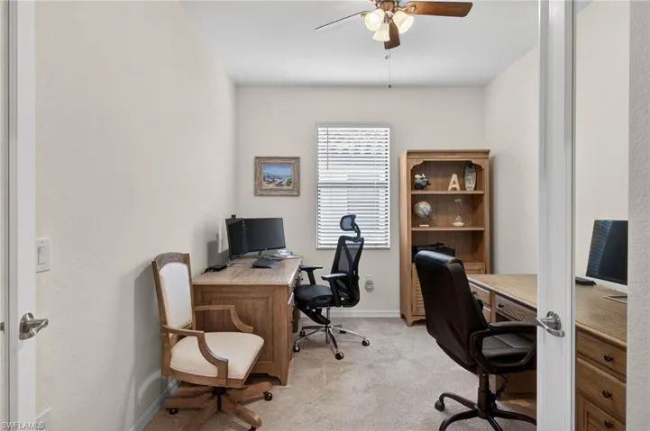 Home office with light carpet and ceiling fan