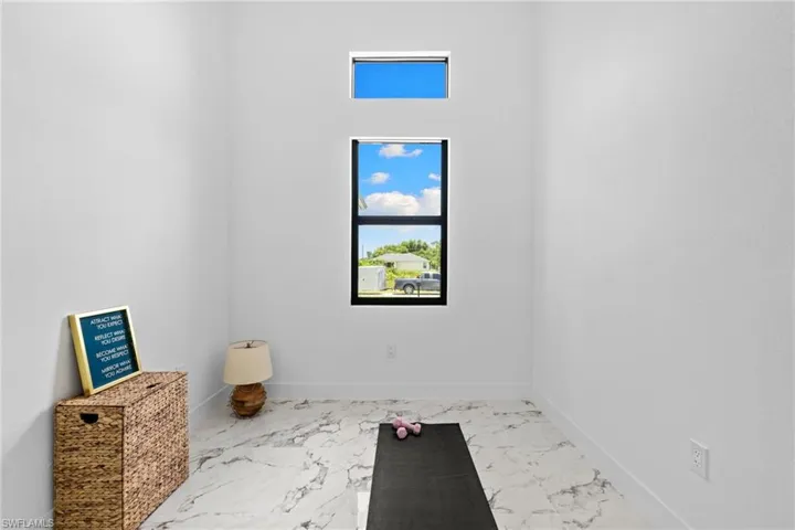 Den with marble look tiles, baseboards and separate doors